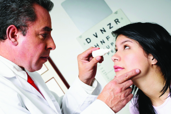 Doctor gives a patient eyedrops