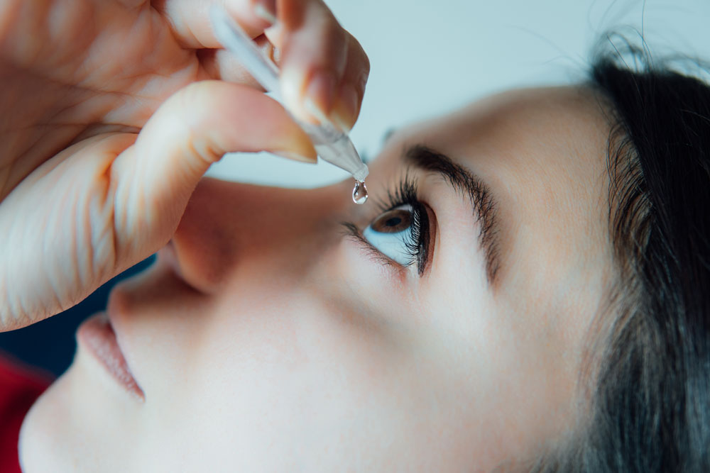 Woman using eye drops