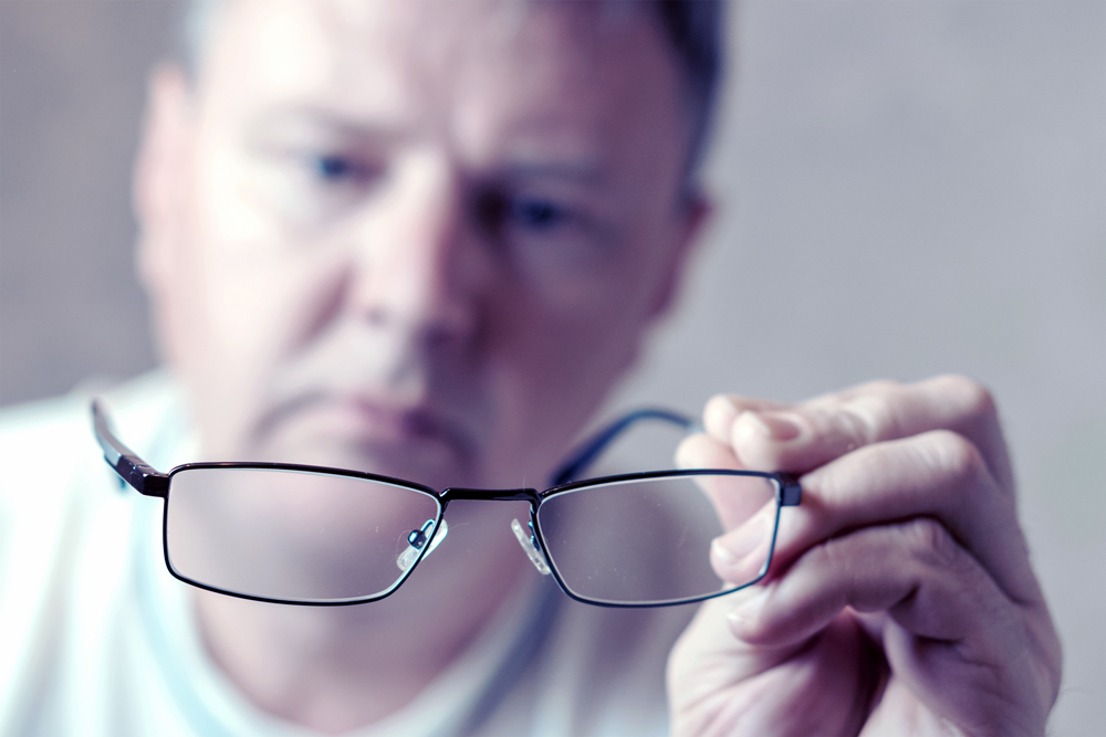 Middle-aged man holding glasses